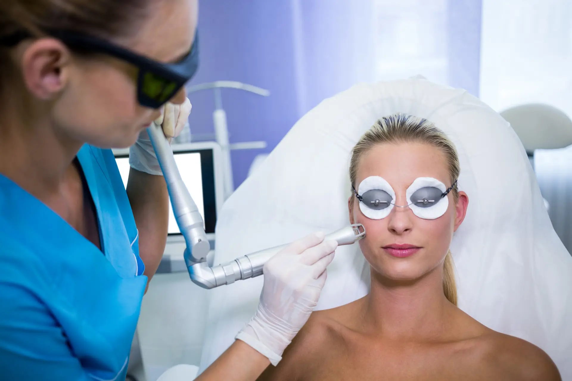 Technician performing a facial laser treatment